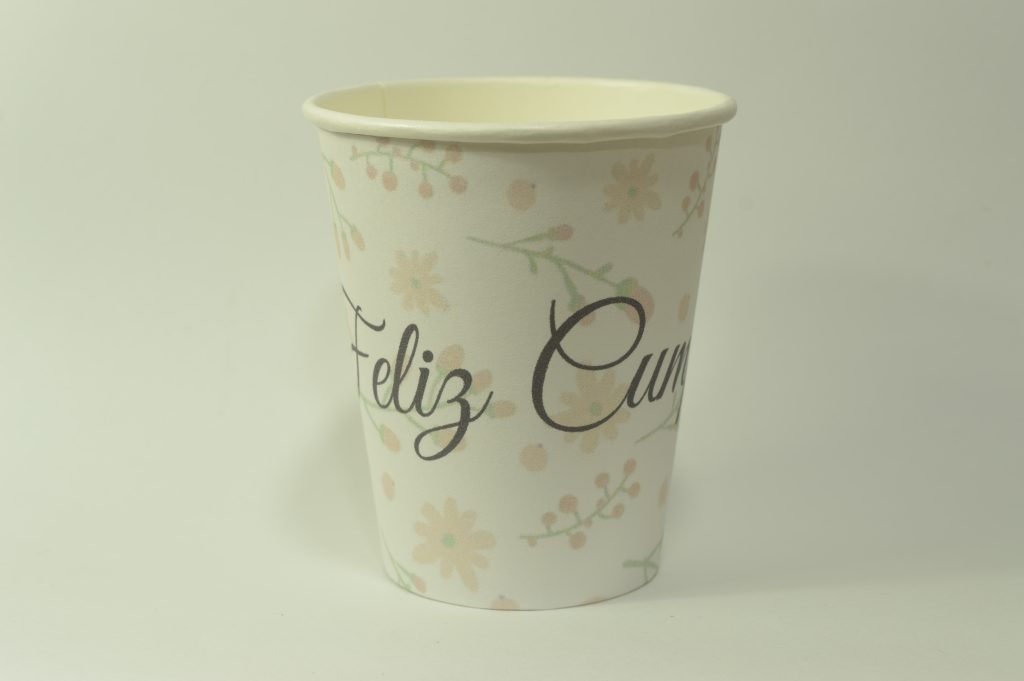Vaso de cumpleaños con flores pastel en tonos rosa y letrero de feliz cumpleaños