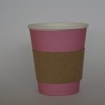 Aislador de calor en cartón puesto en vaso de color de fondo azu
