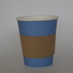 Aislador de calor en cartón puesto en vaso de color de fondo azul